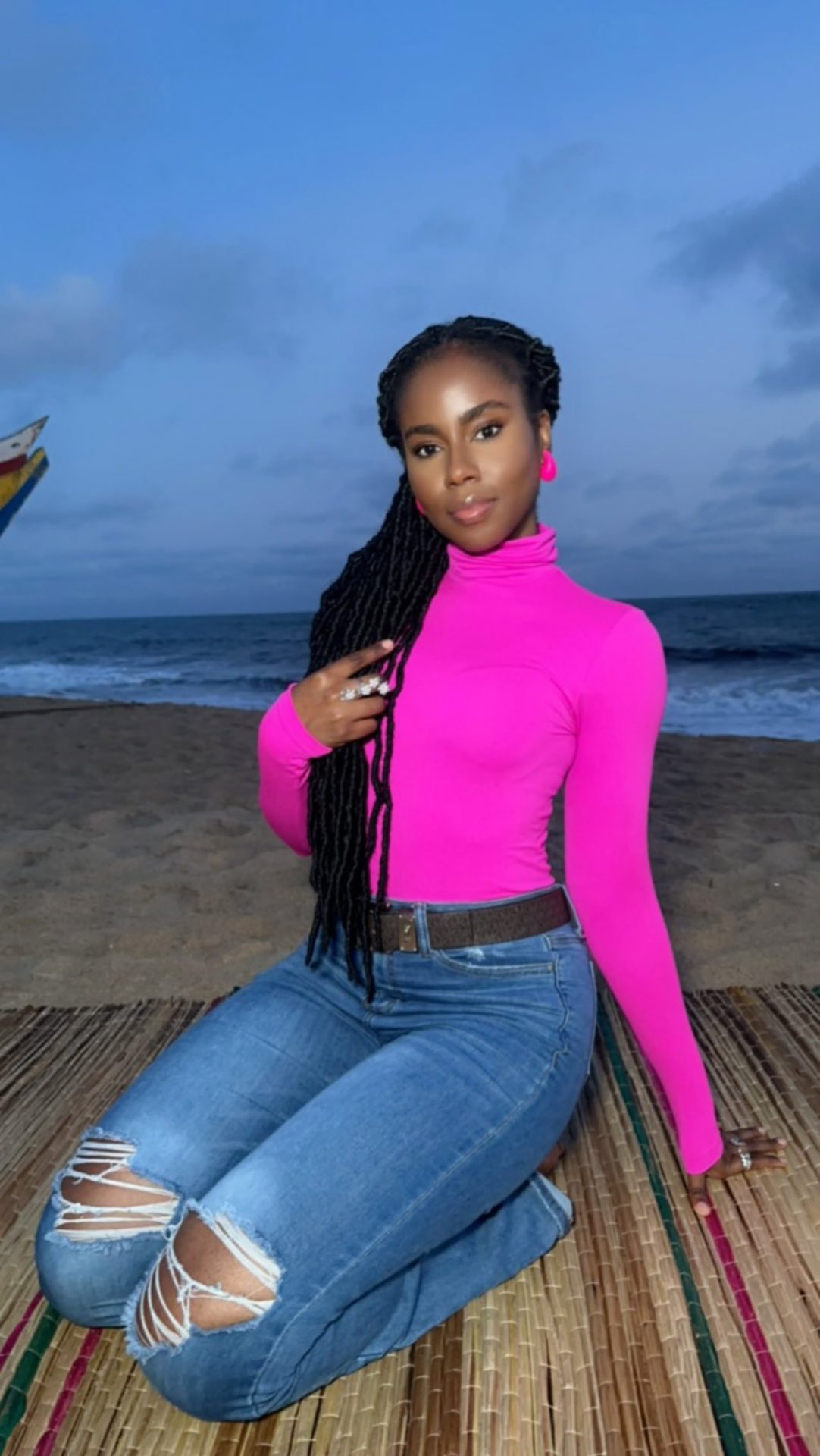 Mz Vee kneels pretty on a mat at the Beach